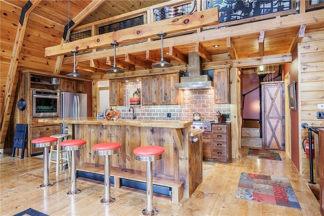 6684 Bishop Rd, Conesus, NY 14435 - kitchen with stainless steel appliances, wall chimney range hood, a wooden ceiling with exposed beams, light wood-style flooring, and brown cabinetry