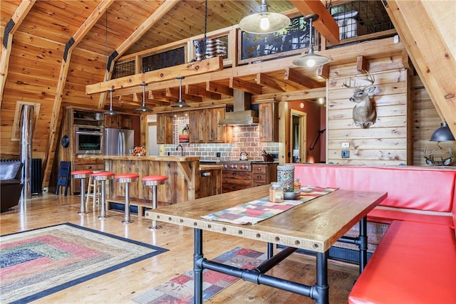6684 Bishop Rd, Conesus, NY 14435 - dining room featuring high vaulted ceiling, wooden walls, light wood-style flooring, and a wood ceiling with exposed beams
