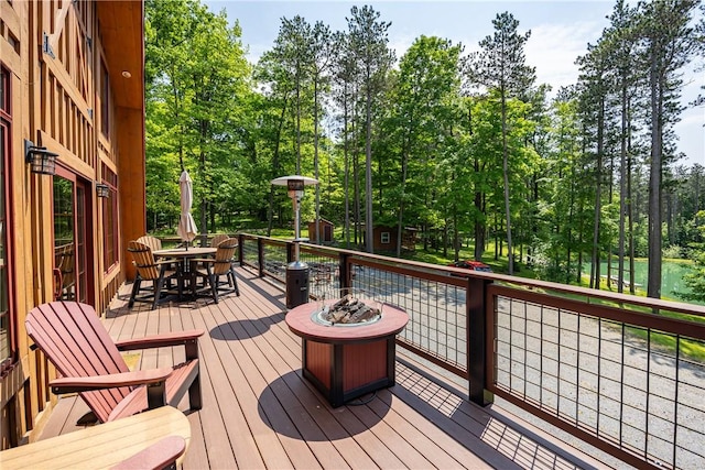 6684 Bishop Rd, Conesus, NY 14435 - deck with a fire pit, outdoor dining area, and view of wooded area