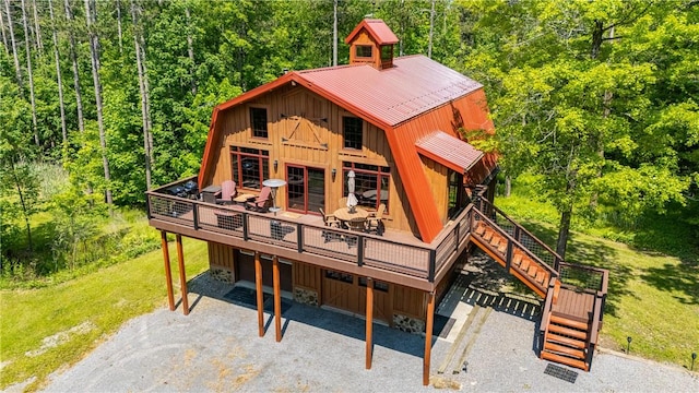 6684 Bishop Rd, Conesus, NY 14435 - view of front facade featuring board and batten siding, a wooden deck, gravel driveway, a metal roof, and a front yard