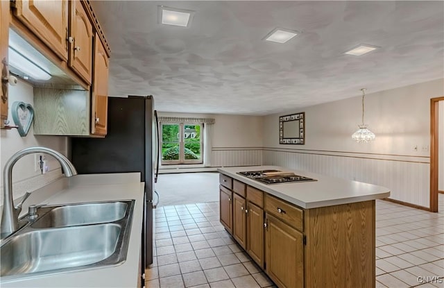 16 Silver Birch Ct, New Hartford, NY 13413 - kitchen with stainless steel stovetop, light tile patterned flooring, a center island, light countertops, and wainscoting