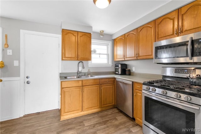 26 Beale Ave, Cheektowaga, NY 14225 - kitchen with appliances with stainless steel finishes, light countertops, light wood-type flooring, and brown cabinetry