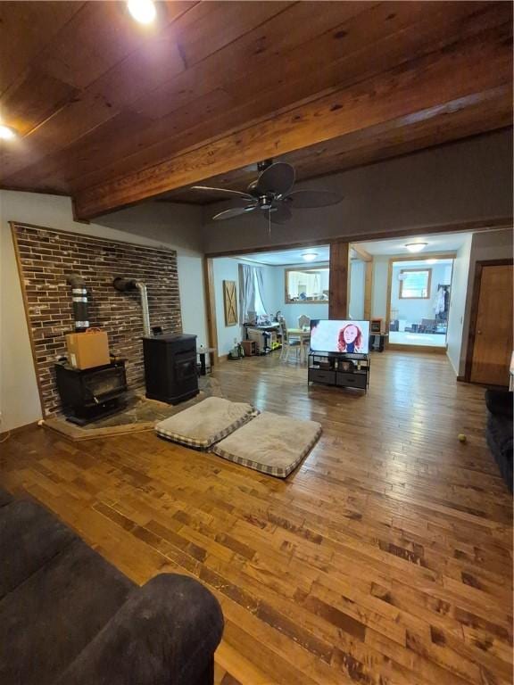 414 Oquaga Lake Rd, Sanford, NY 13754 - living area featuring a wood stove, wood finished floors, ceiling fan, and a wooden ceiling with exposed beams
