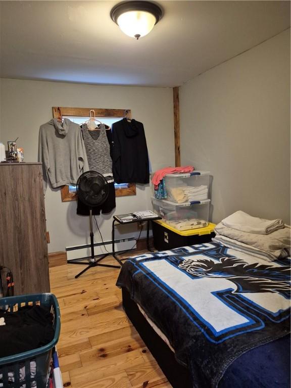 414 Oquaga Lake Rd, Sanford, NY 13754 - bedroom with a baseboard heating unit and light wood-style flooring