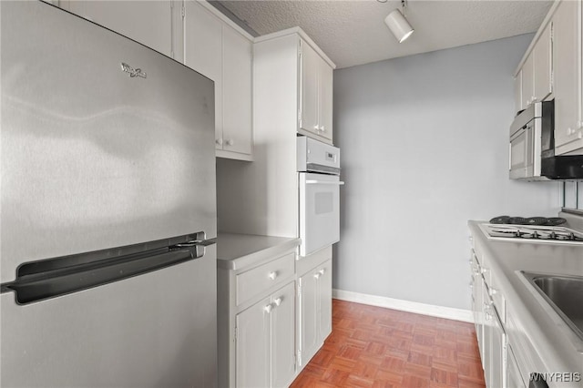 1088 Delaware Ave Unit 9I, Buffalo, NY 14209 - kitchen with appliances with stainless steel finishes, white cabinetry, a textured ceiling, and light countertops