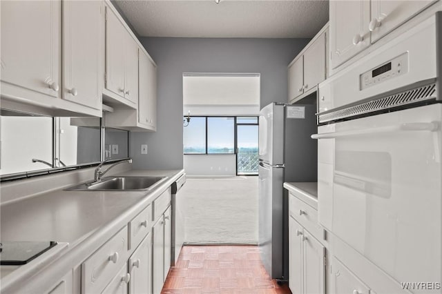 1088 Delaware Ave Unit 9I, Buffalo, NY 14209 - kitchen featuring stainless steel appliances, light colored carpet, light countertops, white cabinetry, and a textured ceiling