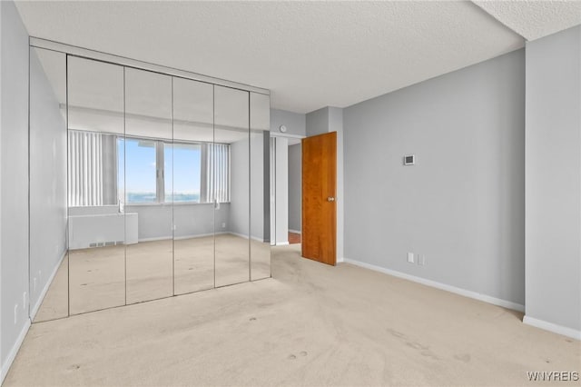 1088 Delaware Ave Unit 9I, Buffalo, NY 14209 - unfurnished bedroom featuring carpet, a textured ceiling, and a closet