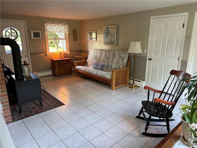 4214 Wilson Burt Rd, Wilson, NY 14172 - living area with a baseboard heating unit, a wainscoted wall, tile patterned floors, a wood stove, and baseboard heating