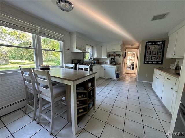4214 Wilson Burt Rd, Wilson, NY 14172 - dining room featuring light tile patterned flooring, a baseboard heating unit, and a brick fireplace
