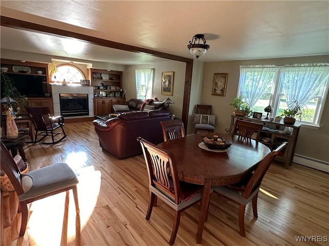 4214 Wilson Burt Rd, Wilson, NY 14172 - dining area with healthy amount of natural light, light wood-style floors, and a tile fireplace