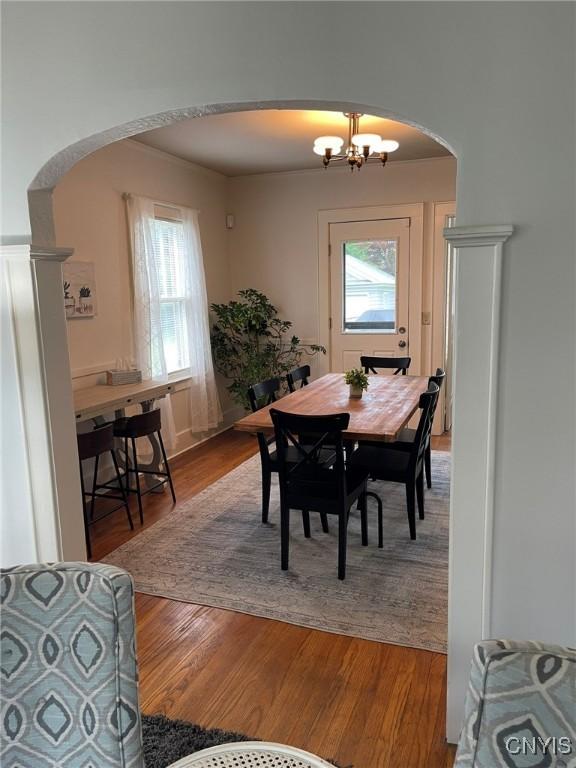 336 Hickok Ave, Syracuse, NY 13206 - dining space with arched walkways, light wood-style flooring, and a chandelier
