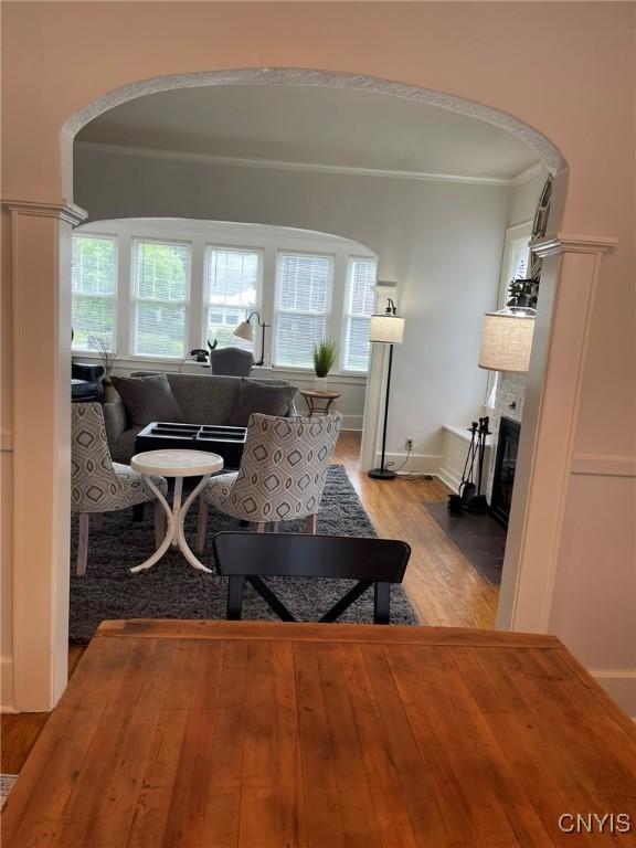 336 Hickok Ave, Syracuse, NY 13206 - living area featuring arched walkways, light wood-type flooring, a fireplace with flush hearth, and ornamental molding