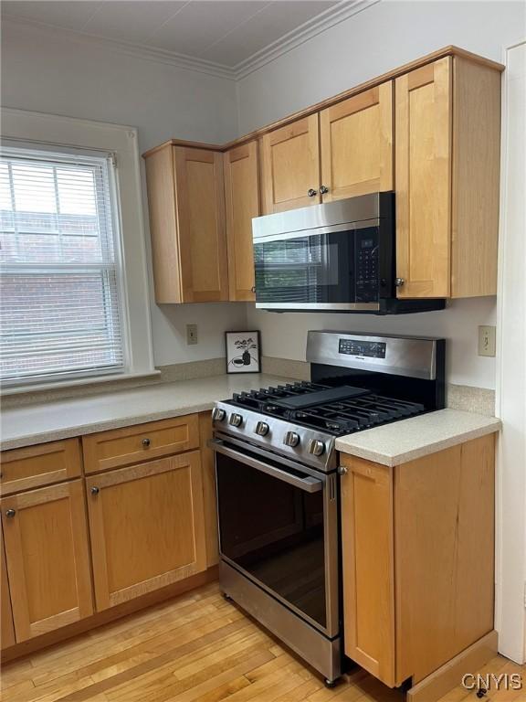 336 Hickok Ave, Syracuse, NY 13206 - kitchen with stainless steel appliances, light countertops, light wood-style floors, crown molding, and light brown cabinetry
