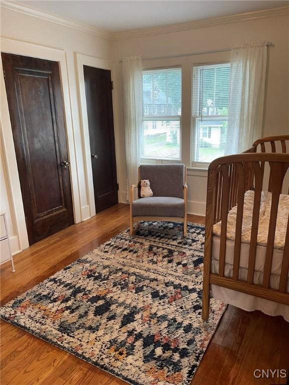 336 Hickok Ave, Syracuse, NY 13206 - bedroom featuring ornamental molding, wood finished floors, and two closets