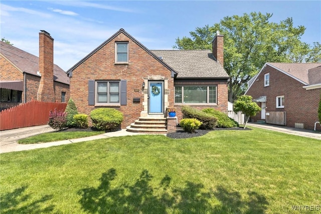 580 Roycroft Blvd, Cheektowaga, NY 14225 - english style home featuring brick siding, a chimney, and a shingled roof