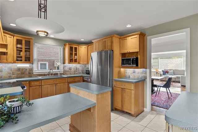 580 Roycroft Blvd, Cheektowaga, NY 14225 - kitchen featuring appliances with stainless steel finishes, light tile patterned flooring, tasteful backsplash, glass insert cabinets, and a center island