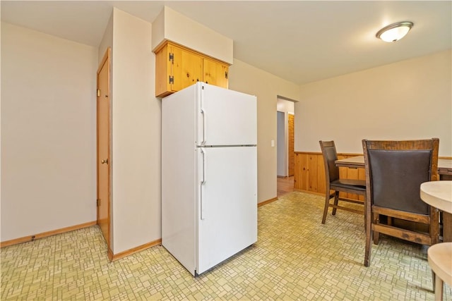 970 Elmgrove Rd, Gates, NY 14624 - kitchen featuring freestanding refrigerator, light flooring, and a wainscoted wall