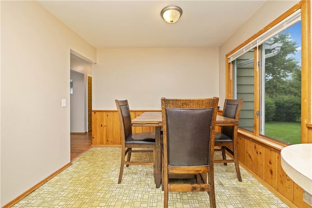 970 Elmgrove Rd, Gates, NY 14624 - dining room featuring wooden walls, healthy amount of natural light, wainscoting, and brick patterned floors