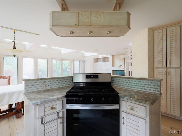 21751 Hewitt Dr, Champion, NY 13619 - kitchen with stainless steel range with gas stovetop, backsplash, a skylight, and light wood-type flooring