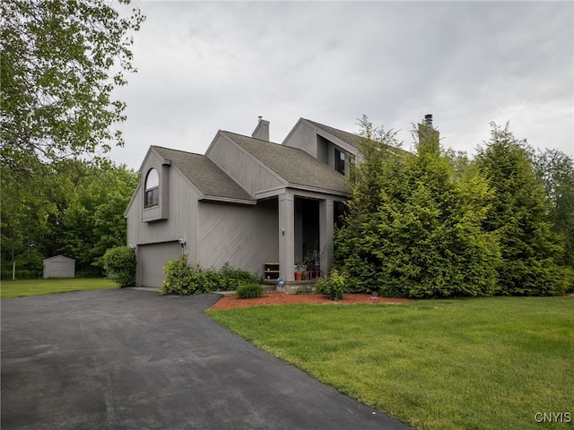 21751 Hewitt Dr, Champion, NY 13619 - view of front facade with a front lawn, a chimney, a garage, driveway, and a storage unit