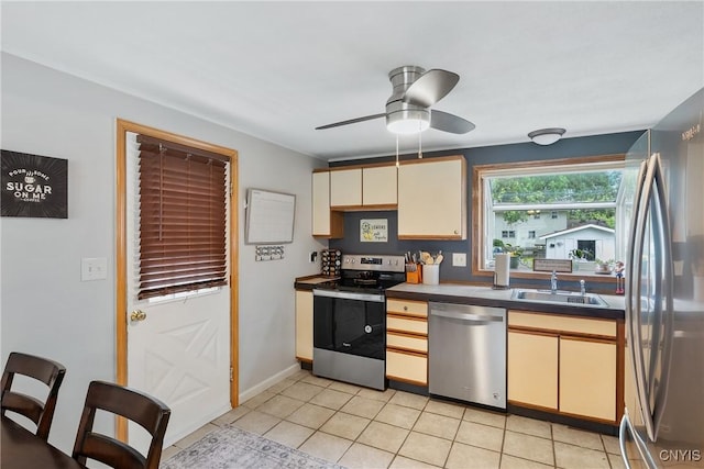 120 Gordon Rd, Clay, NY 13212 - kitchen with stainless steel appliances, dark countertops, a ceiling fan, cream cabinetry, and light tile patterned floors