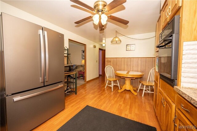 241 Shanley St, Cheektowaga, NY 14206 - dining area with light wood finished floors, ceiling fan, wainscoting, and wooden walls