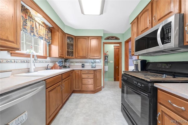 749 Colvin Blvd, Tonawanda-Town, NY 14217 - kitchen with stainless steel appliances, brown cabinets, light countertops, light floors, and glass insert cabinets