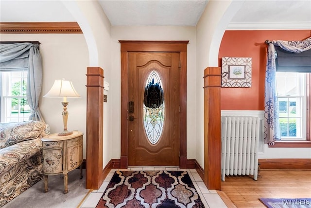 749 Colvin Blvd, Tonawanda-Town, NY 14217 - foyer featuring radiator heating unit, arched walkways, and light wood-style flooring