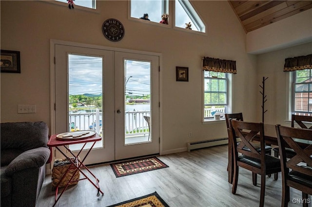 142 S Shore Rd, Webb, NY 13420 - dining room featuring french doors, plenty of natural light, a baseboard radiator, light wood finished floors, and high vaulted ceiling