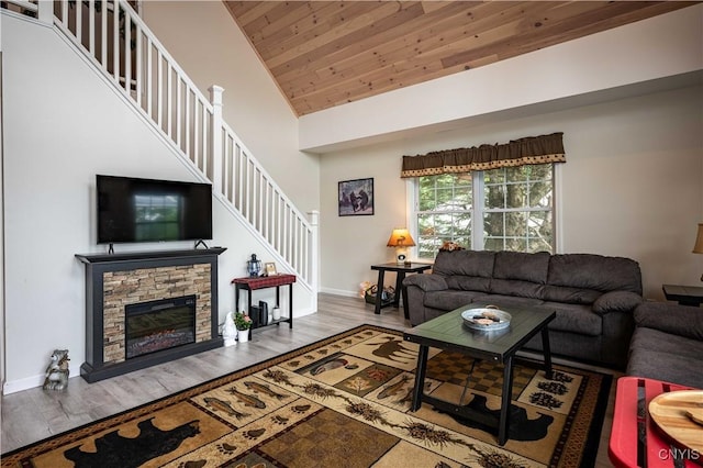 142 S Shore Rd, Webb, NY 13420 - living area featuring stairs, wood finished floors, wood ceiling, a stone fireplace, and high vaulted ceiling