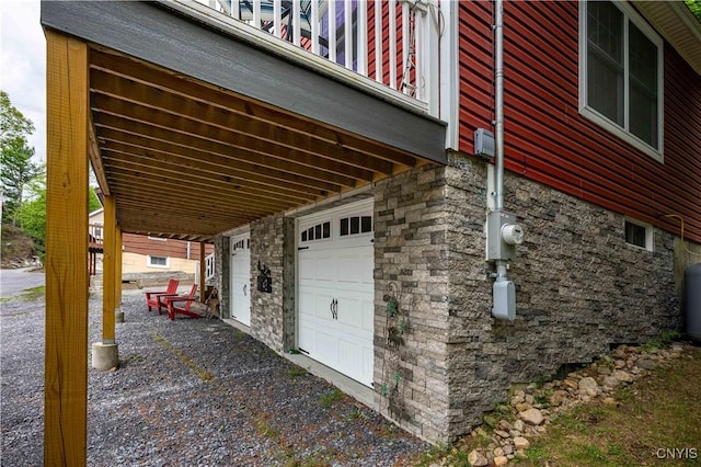 142 S Shore Rd, Webb, NY 13420 - view of side of property featuring stone siding, an attached garage, and driveway