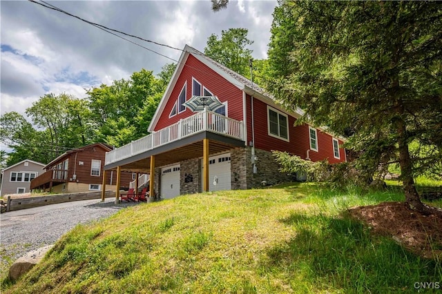 142 S Shore Rd, Webb, NY 13420 - view of front of house featuring stone siding, an attached garage, a wooden deck, and driveway