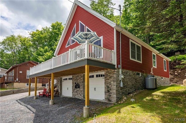 142 S Shore Rd, Webb, NY 13420 - view of side of property with an attached garage, a deck, and driveway