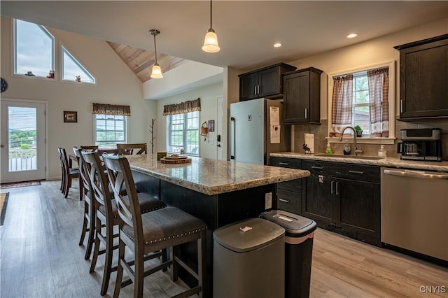 142 S Shore Rd, Webb, NY 13420 - kitchen featuring stainless steel dishwasher, light wood-style floors, a kitchen bar, a center island, and vaulted ceiling
