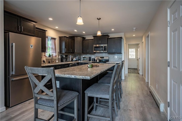 142 S Shore Rd, Webb, NY 13420 - kitchen featuring stainless steel appliances, baseboard heating, dark brown cabinets, light wood finished floors, and a breakfast bar