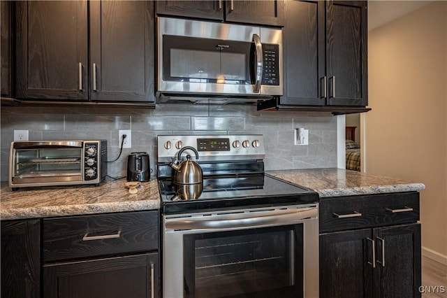 142 S Shore Rd, Webb, NY 13420 - kitchen with appliances with stainless steel finishes, backsplash, light stone countertops, and wood finished floors