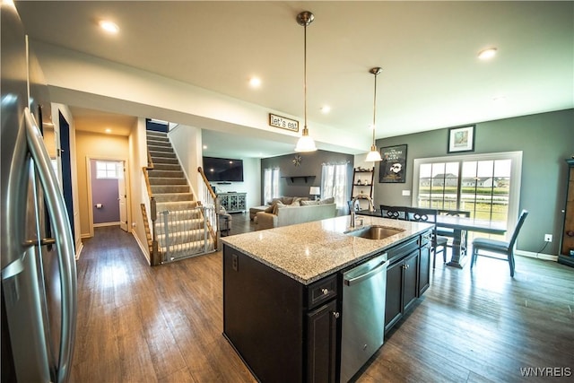 510 Limestone Ct, Grand Island, NY 14072 - kitchen featuring stainless steel appliances, light stone counters, dark wood finished floors, pendant lighting, and an island with sink