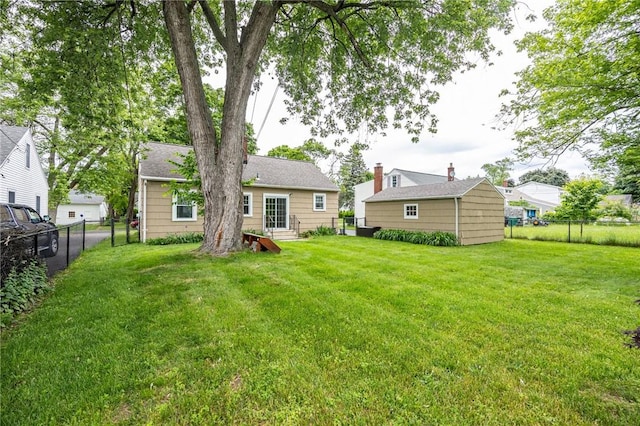 309 Brandon Rd, Irondequoit, NY 14622 - rear view of house with a fenced backyard and an outdoor structure