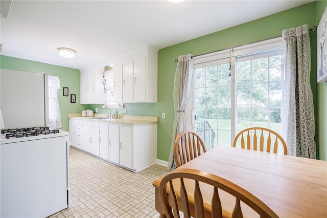 309 Brandon Rd, Irondequoit, NY 14622 - kitchen with white appliances, white cabinetry, and light countertops