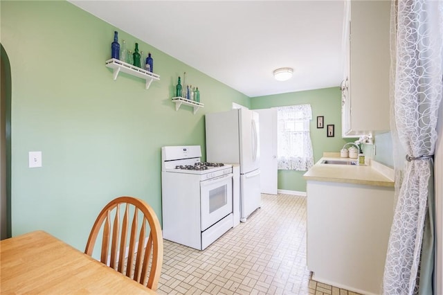 309 Brandon Rd, Irondequoit, NY 14622 - kitchen featuring white appliances, light countertops, and arched walkways