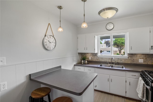 316 Walzer Rd, Irondequoit, NY 14622 - kitchen with dark countertops, white cabinets, a kitchen breakfast bar, gas range, and backsplash