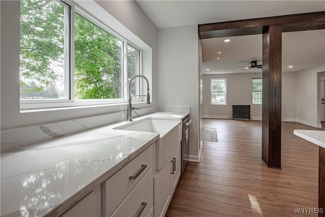 7395 W Somerset Rd, Somerset, NY 14008 - kitchen with radiator heating unit, white cabinets, light wood-type flooring, ceiling fan, and stainless steel dishwasher