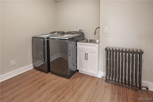 7395 W Somerset Rd, Somerset, NY 14008 - laundry room featuring radiator, separate washer and dryer, light wood-style floors, and cabinet space