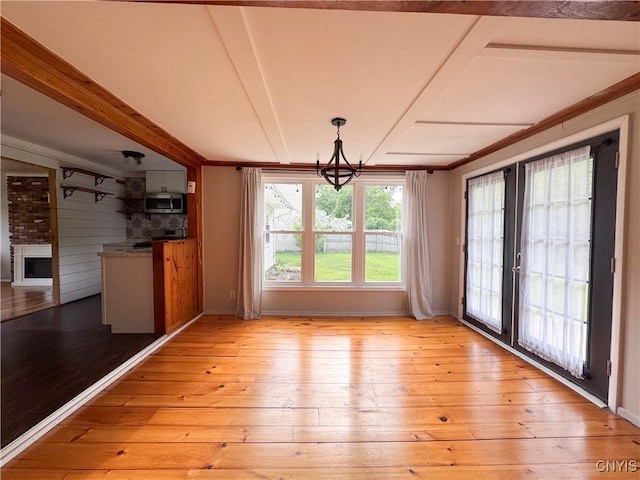 16 Tyler Ct, Manlius, NY 13104 - unfurnished dining area with light wood finished floors, a chandelier, a fireplace, and french doors