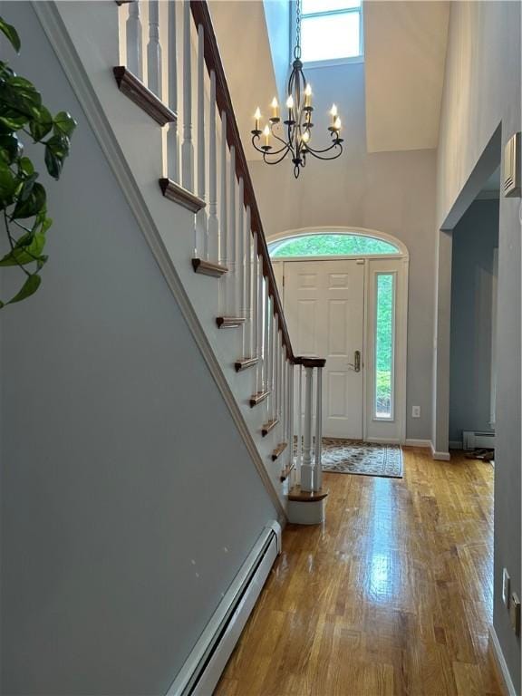 38 Hemlock Ln, Erwin, NY 14870 - entryway featuring a towering ceiling, a chandelier, a baseboard heating unit, wood finished floors, and stairway
