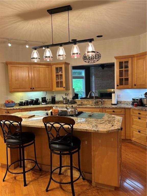 38 Hemlock Ln, Erwin, NY 14870 - kitchen featuring a center island, ornamental molding, a kitchen breakfast bar, glass insert cabinets, and light stone counters
