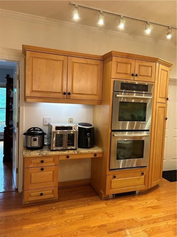 38 Hemlock Ln, Erwin, NY 14870 - kitchen featuring rail lighting, stainless steel double oven, light wood-style flooring, light stone counters, and crown molding
