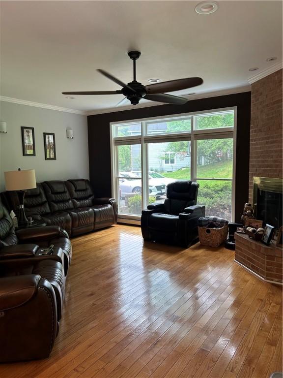 38 Hemlock Ln, Erwin, NY 14870 - living area featuring a ceiling fan, ornamental molding, a brick fireplace, and hardwood / wood-style floors