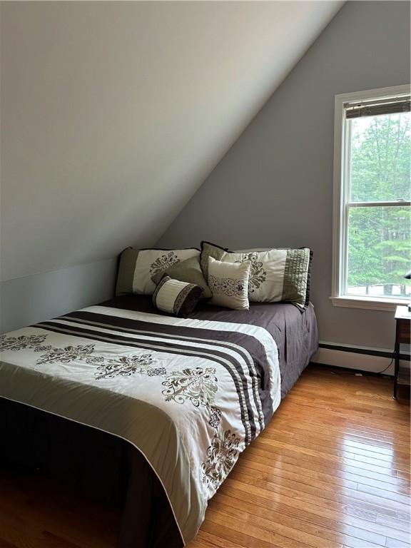 38 Hemlock Ln, Erwin, NY 14870 - bedroom with a baseboard radiator, vaulted ceiling, and light wood-style floors