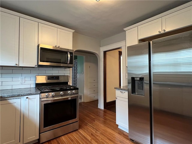 534 Mount Zoar St, Elmira-City, NY 14904 - kitchen featuring appliances with stainless steel finishes, arched walkways, white cabinets, and dark wood finished floors